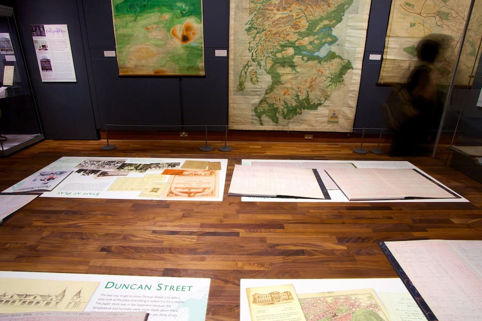 Una exposición de museo con documentos históricos y mapas.