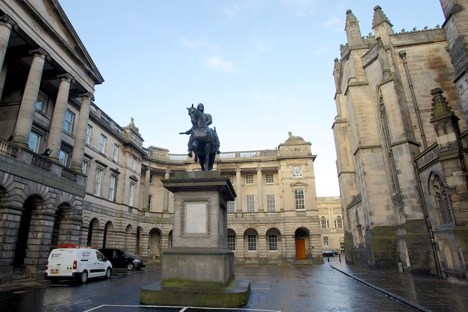 Una estàtua d'un cavaller en una plaça envoltada d'edificis històrics.