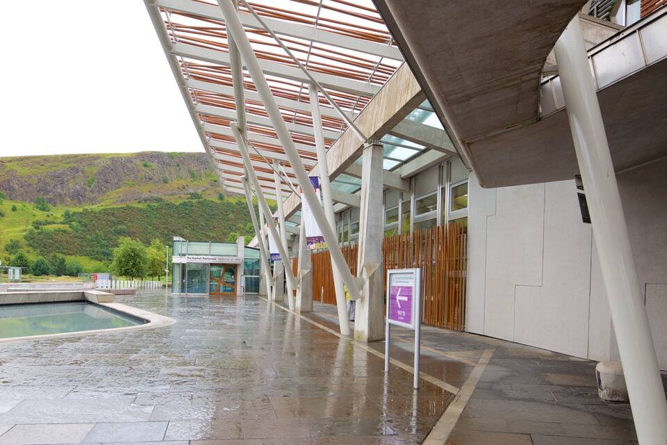 A modern building with a glass facade, a covered outdoor area, and a pool.