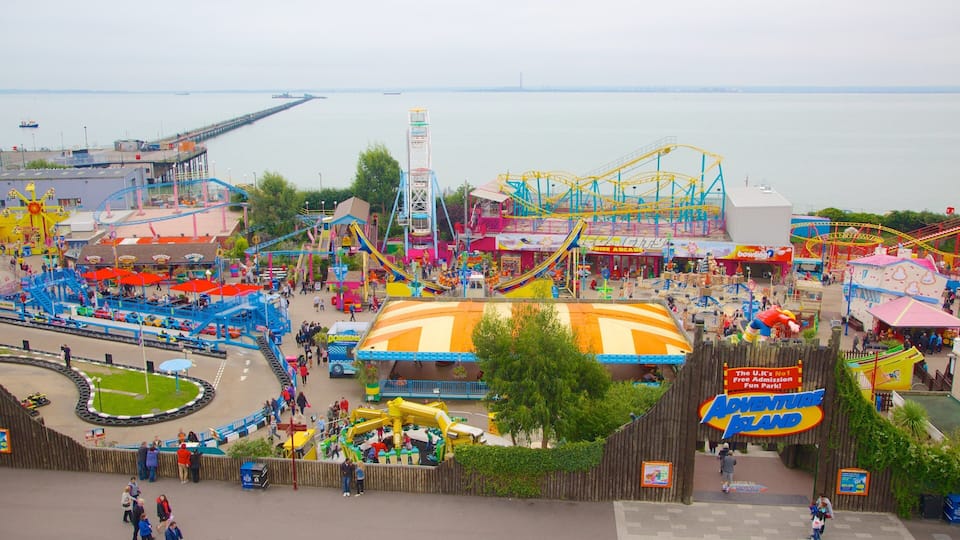 An amusement park with roller coasters, a Ferris wheel, and a large yellow building.