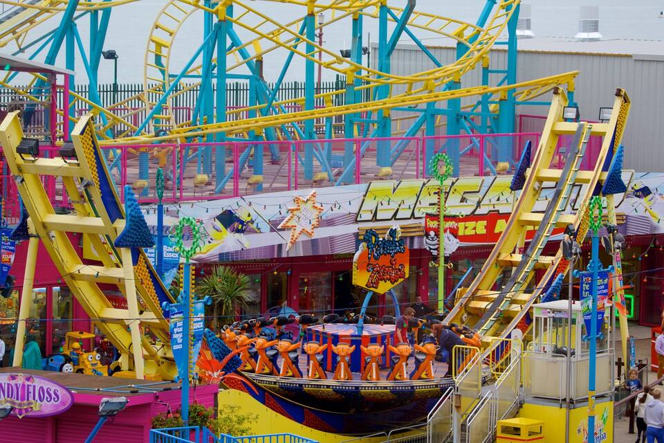 A colorful amusement park with a Ferris wheel, a boat ride, and various rides and attractions.