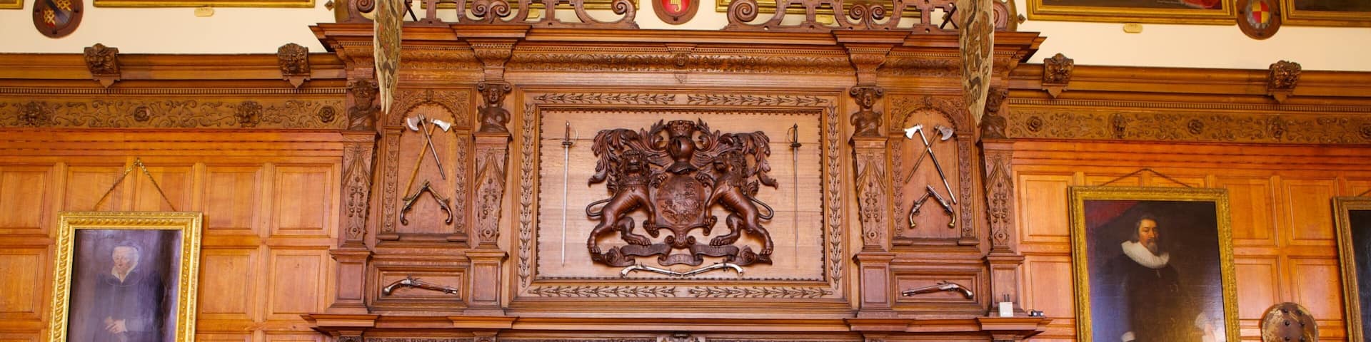 An ornate wooden fireplace with intricate carvings and a central coat of arms.