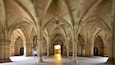 A cathedral interior with high vaulted ceilings and a central aisle leading to a doorway.