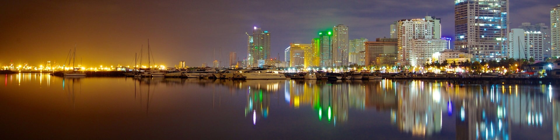 Baywalk featuring a bay or harbor, a high rise building and a city