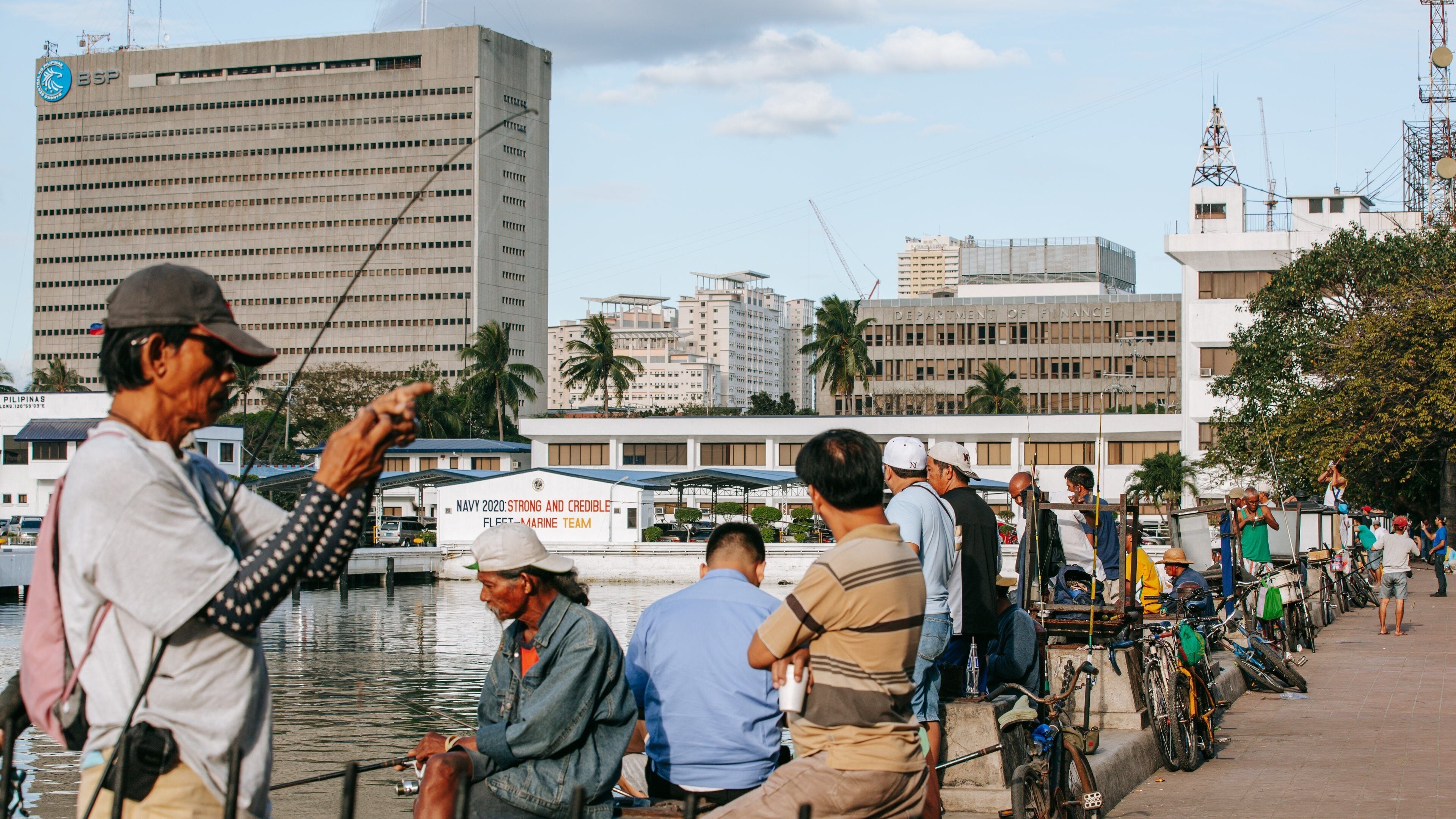 Baywalk which includes fishing and a bay or harbor as well as a small group of people