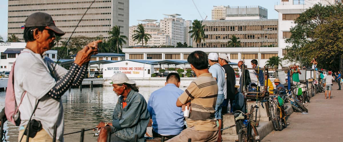 Baywalk which includes fishing and a bay or harbor as well as a small group of people