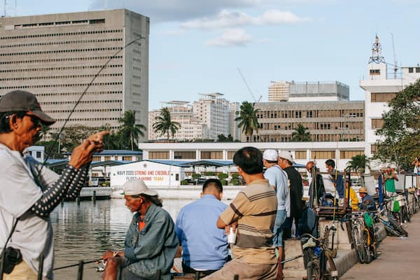 Baywalk which includes fishing and a bay or harbor as well as a small group of people