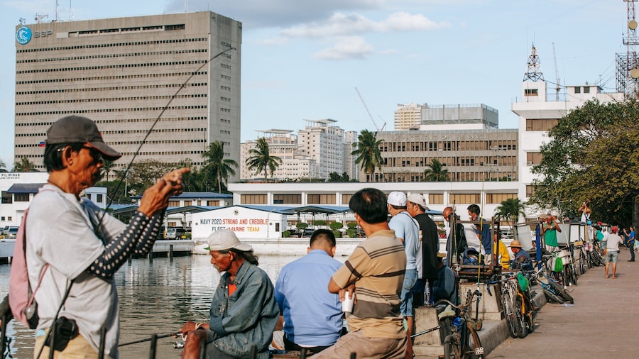 Baywalk which includes fishing and a bay or harbor as well as a small group of people