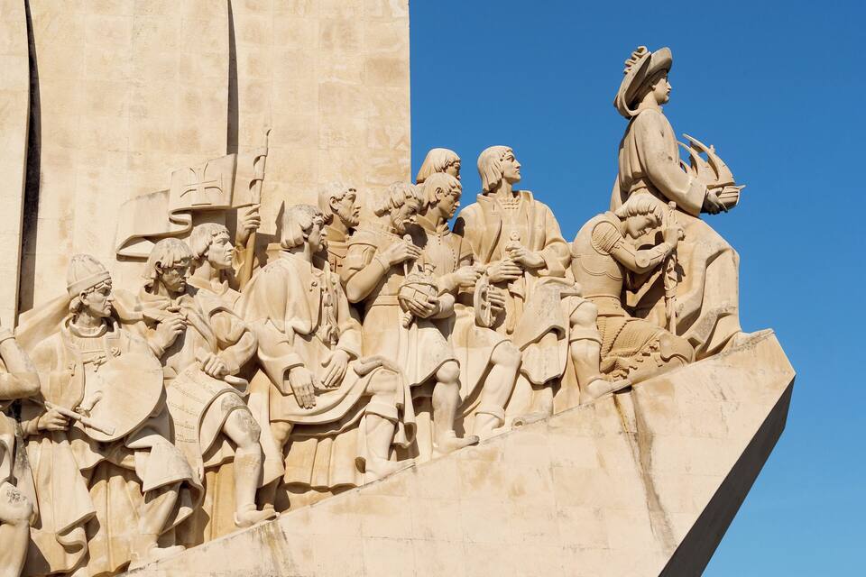 A detailed stone relief sculpture of a historical scene with figures holding various objects.