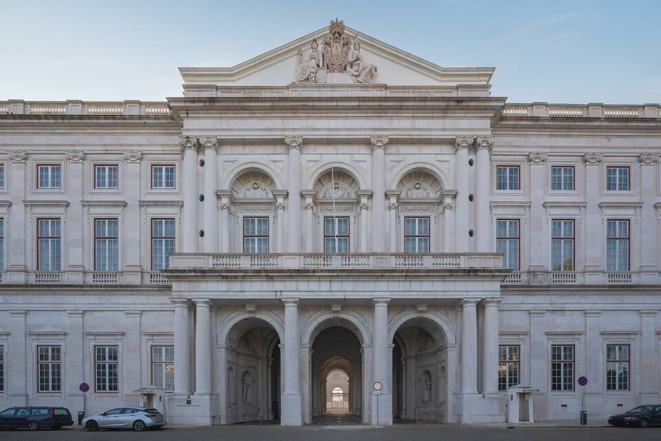 Een statig neoclassicistisch gebouw met symmetrische architectuur, grote ramen en een centrale ingang met drie bogen.