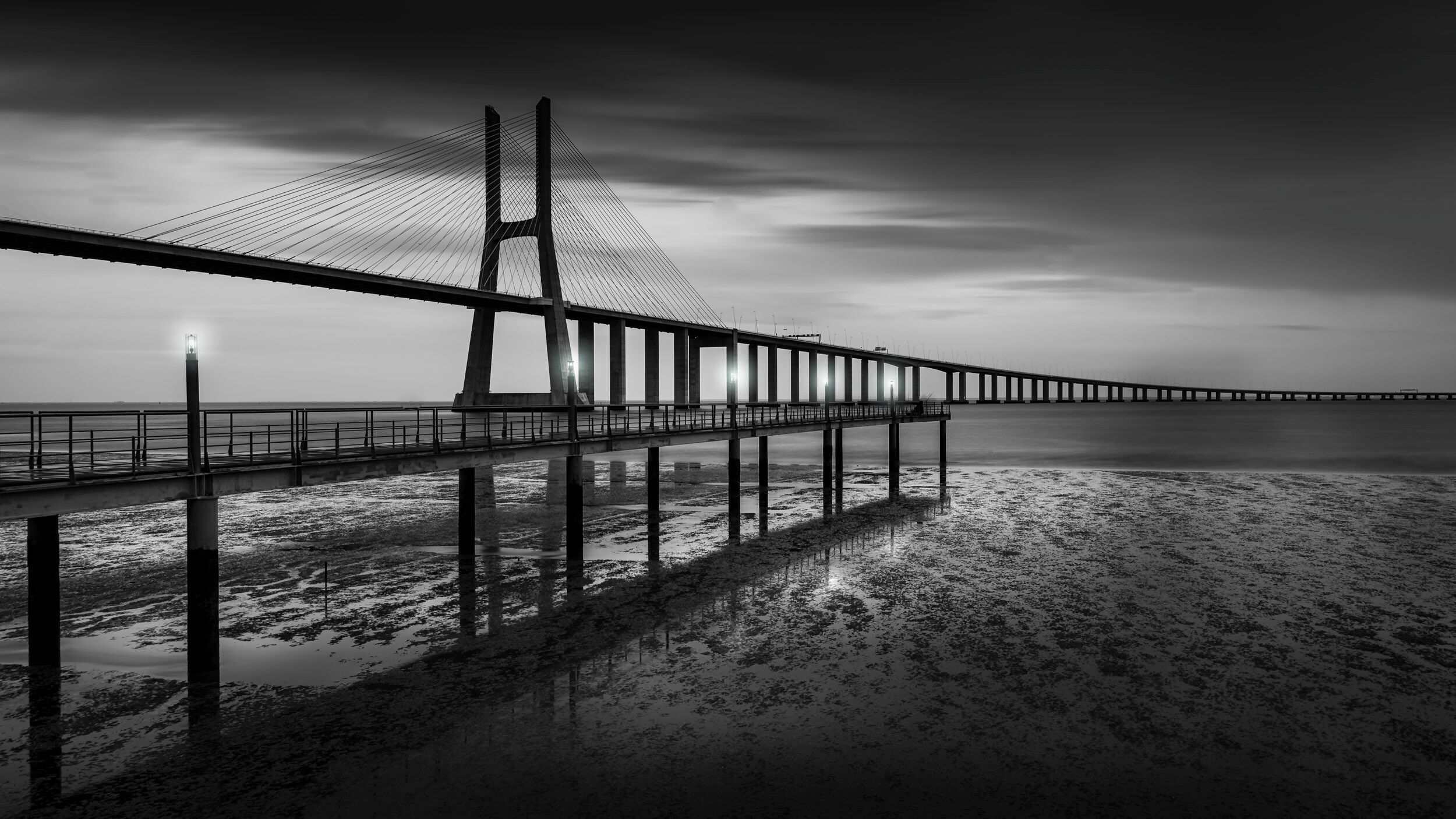 The Vasco da Gama bridge is the 2nd longest bridge in Europe and amazing spot to photograph and see when you visiting Lisbon, Portugal. This view is from the Jardim do Passeio dos Heróis do Mar park.