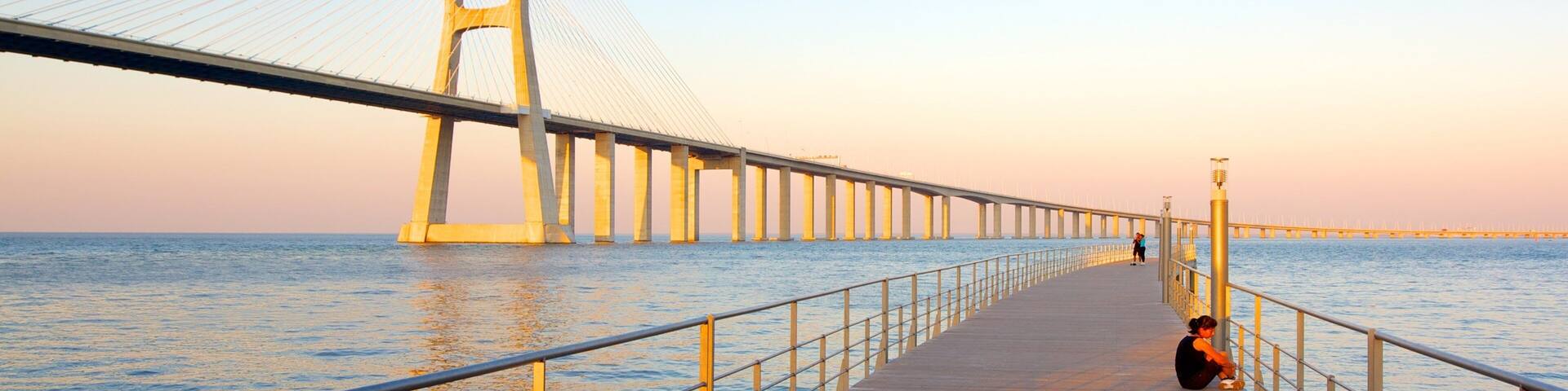 Vasco da Gama Bridge which includes a bridge, a sunset and a bay or harbor