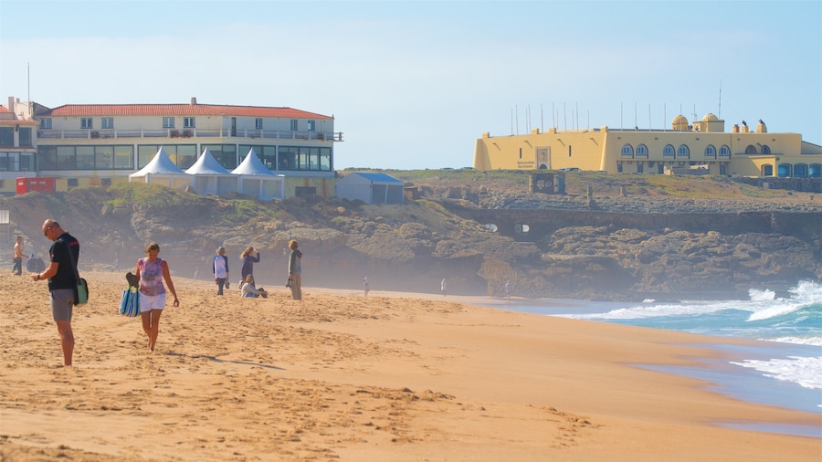 Playa Guincho ofreciendo una ciudad costera, vistas generales de la costa y una playa de arena