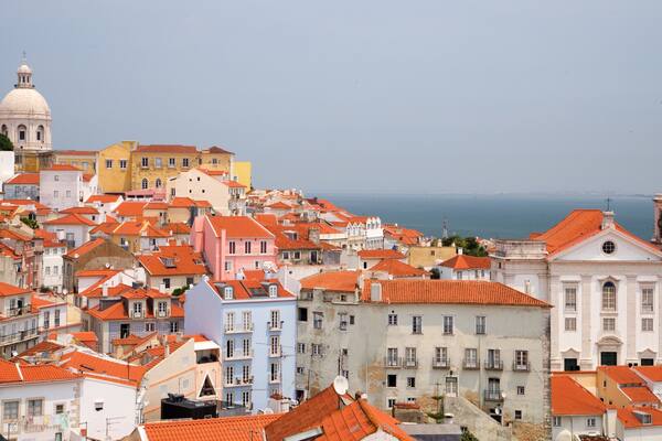 A coastal cityscape with colorful buildings and a prominent church with a dome.