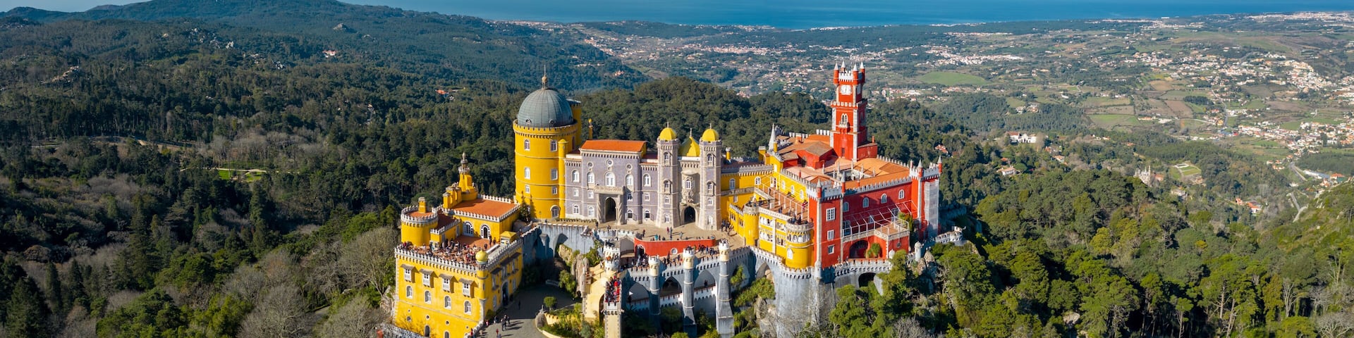 Aerial view of Pena Palace, castle stands on Sintra Mountains; monument and one of the Seven Wonders of Portugal, mixture of eclectic styles includes the Neo-Gothic, Manueline, Islamic, Renaissance