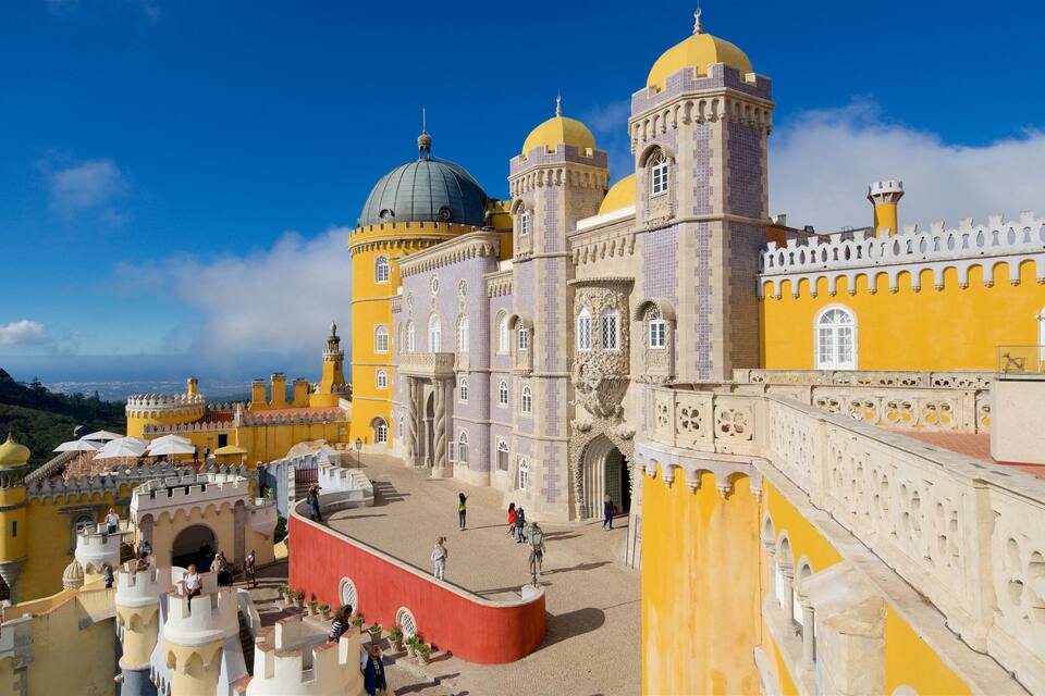 Palacio de Pena, con su fachada distintiva amarillo y blanco, torres abovedadas y balcones ornamentados.