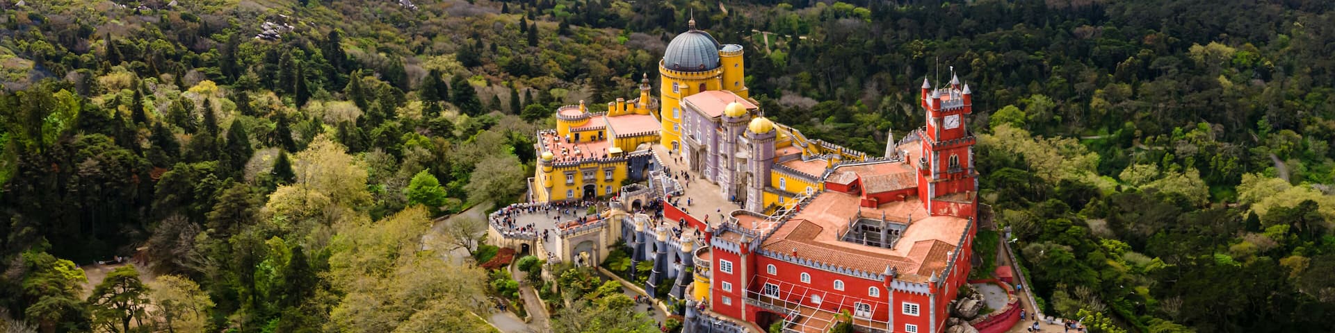 A castle surrounded by lush greenery and hills.