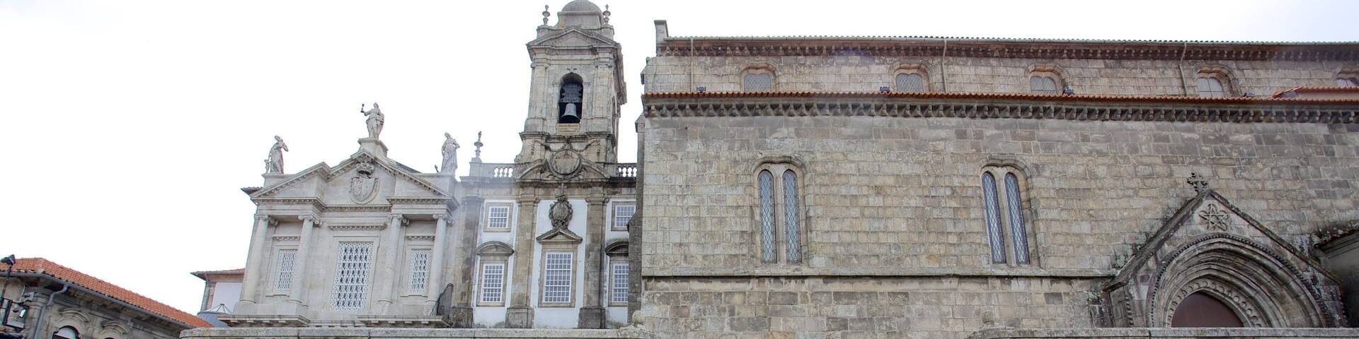 A historic building with a bell tower and a staircase leading to a higher level.