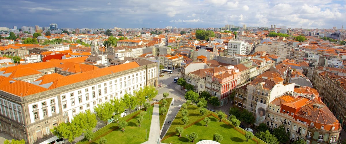 A cityscape with red-roofed buildings, a large white building, and a green park area.