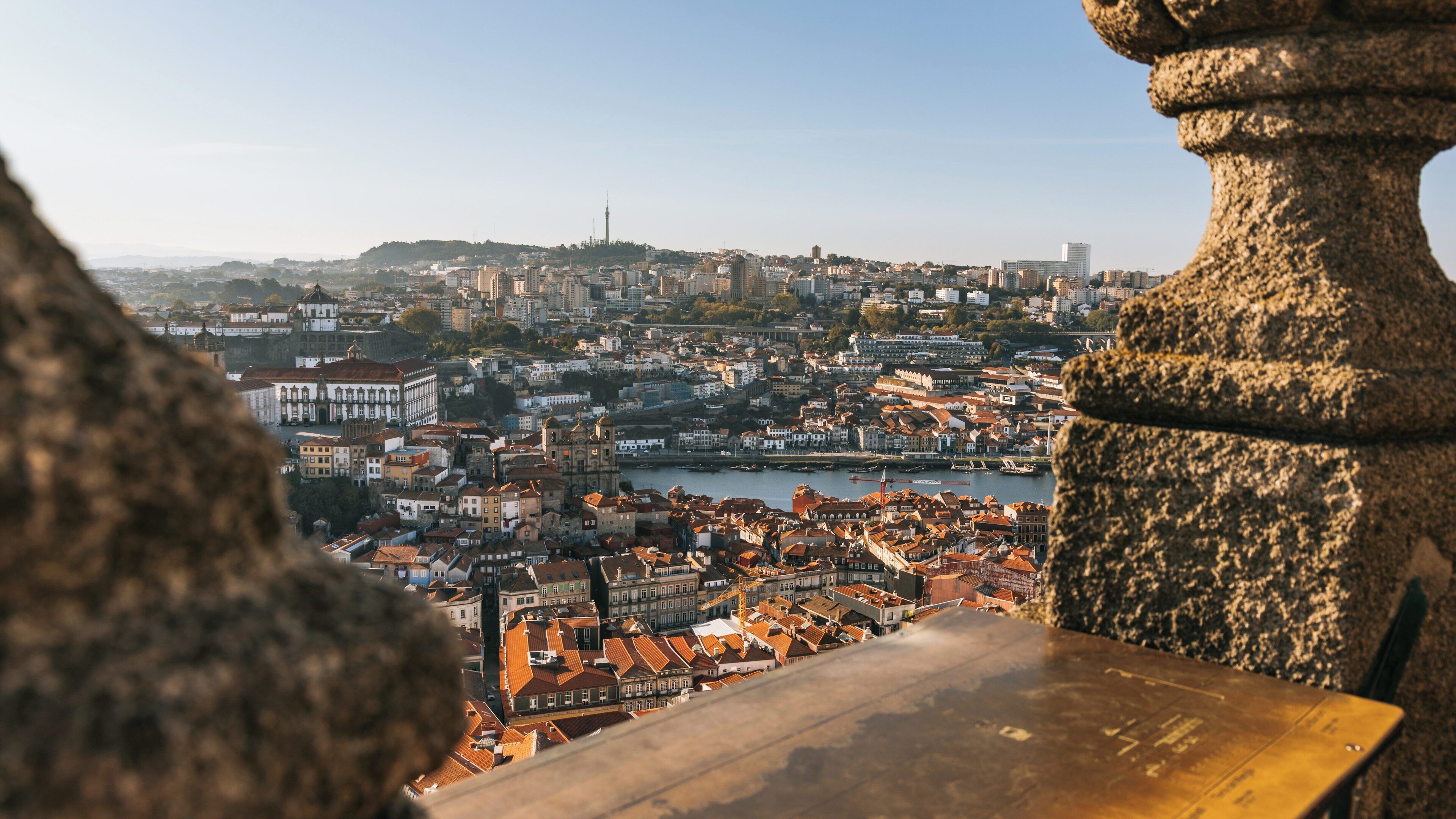 Stunning view of Porto's skyline with Clérigos Church amidst vibrant buildings and the Douro River under clear blue skies