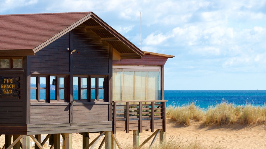 Un bar de playa de madera con vistas al océano.