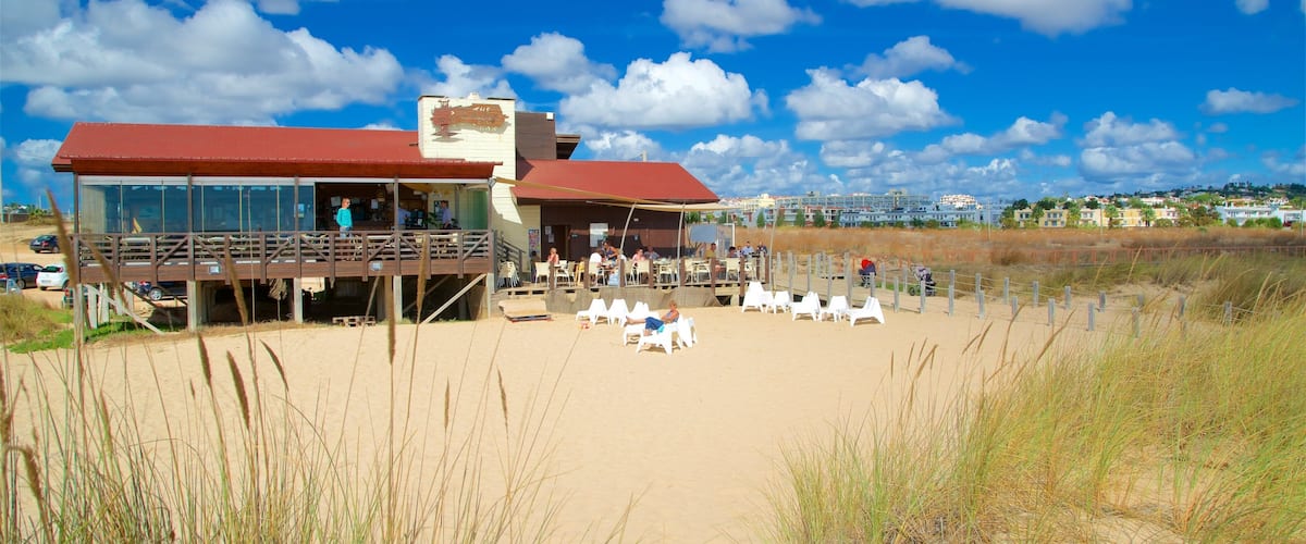 A beachside restaurant with outdoor seating and a view of the ocean.