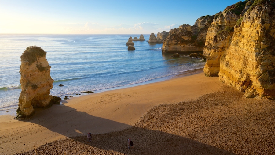 Dona Ana Beach showing a sunset, a sandy beach and rocky coastline