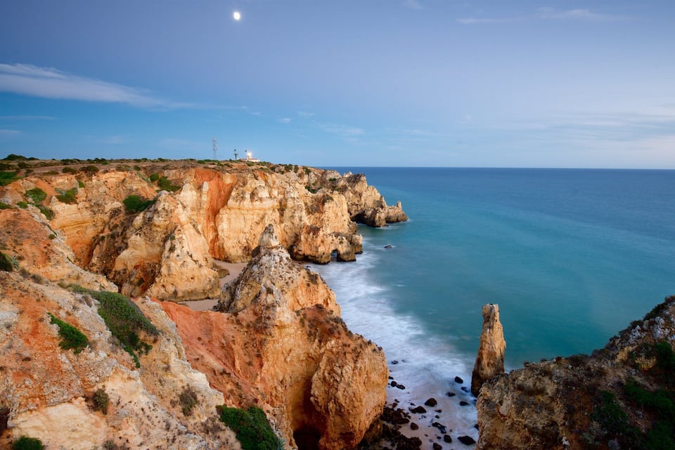 Paisagem costeira com falésias rochosas e vista clara do oceano.