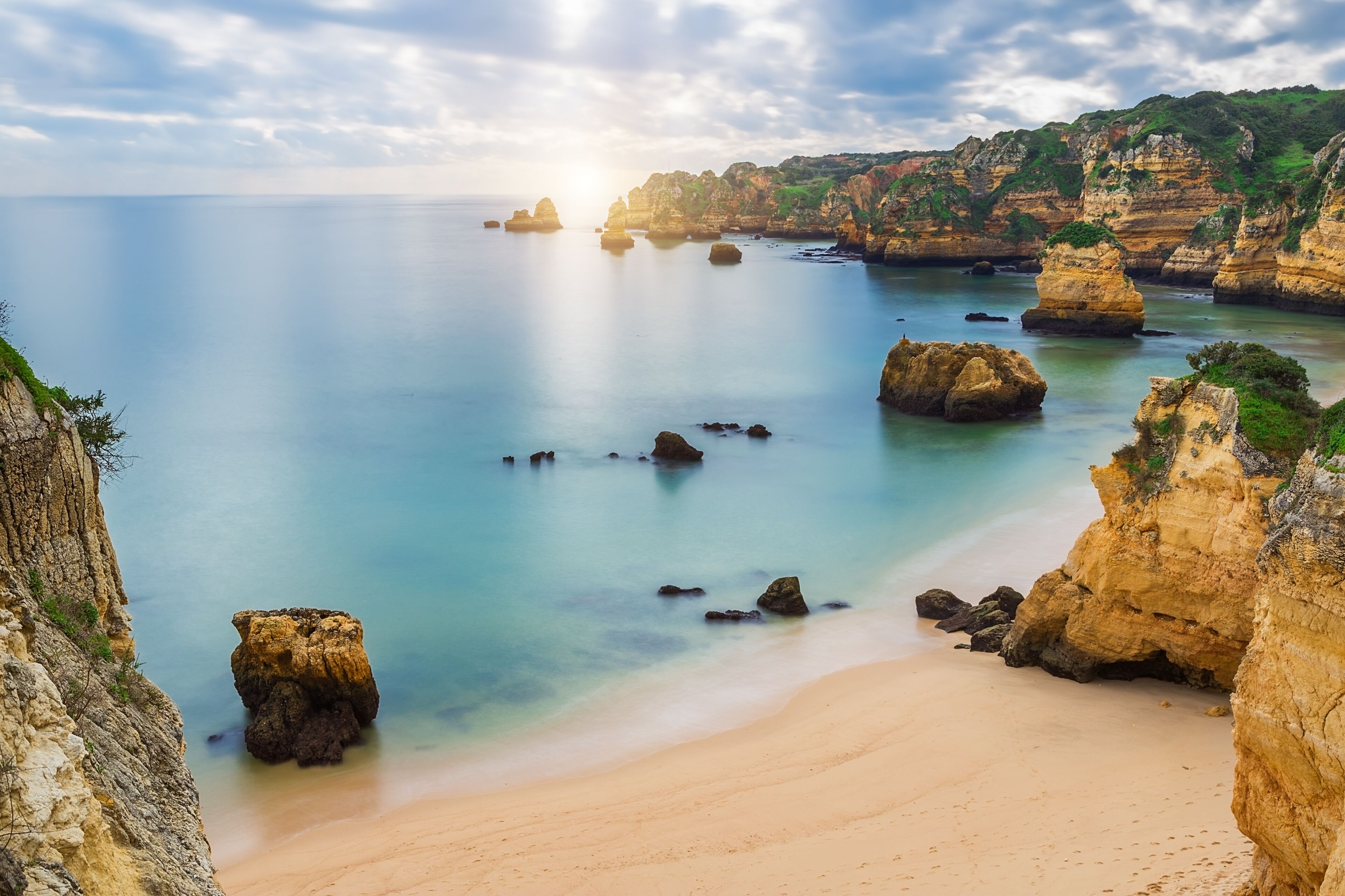 Sea beach at sunset. Cloudy sky. Portugal, Algarve, Lagos.