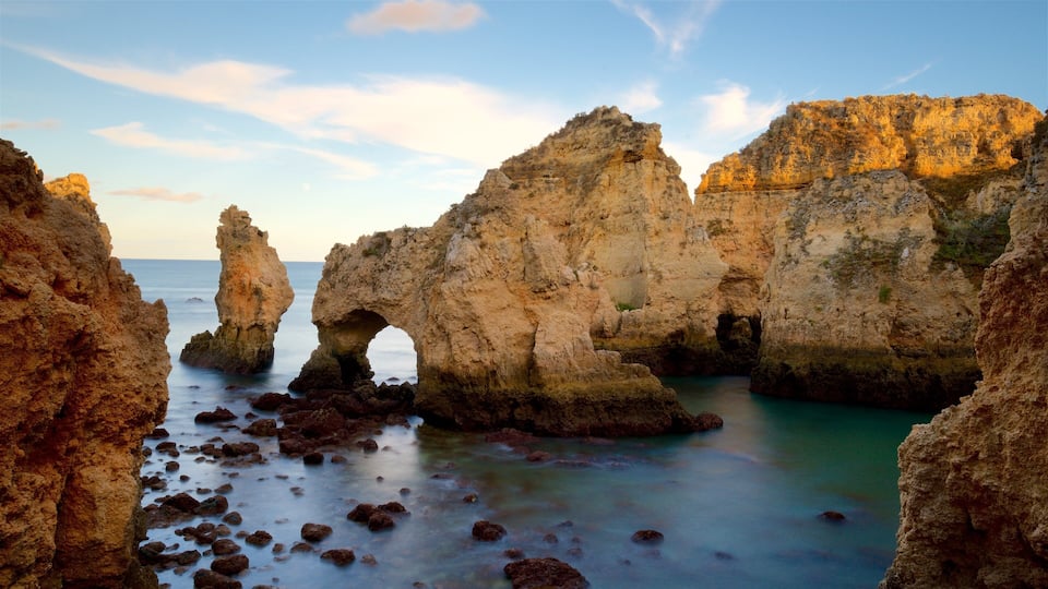 A coastal landscape with rocky formations and a clear blue sky.