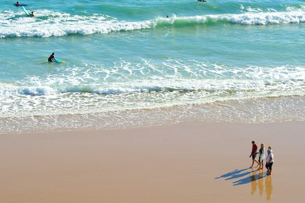Porto de Mos Beach showing a beach and general coastal views as well as a small group of people