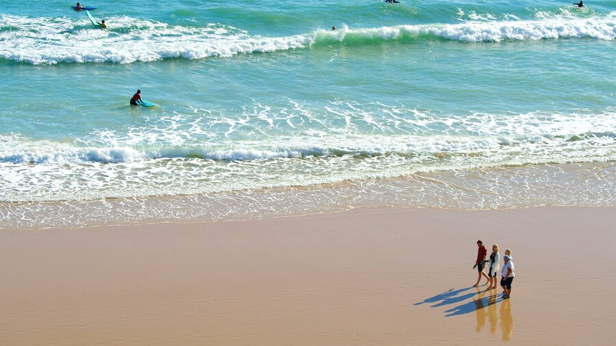 Porto de Mos Beach showing a beach and general coastal views as well as a small group of people