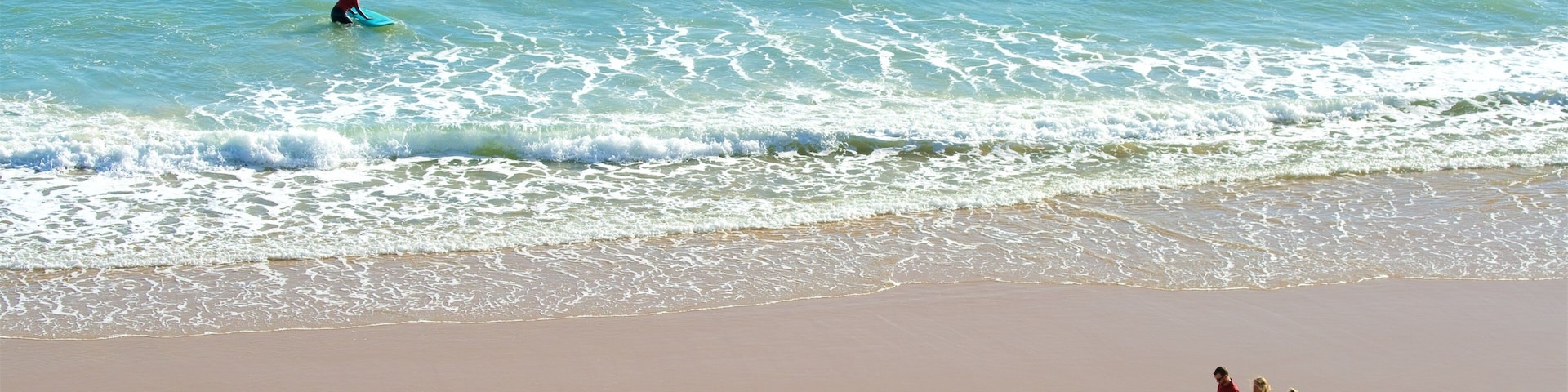 Porto de Mos Beach showing a beach and general coastal views as well as a small group of people