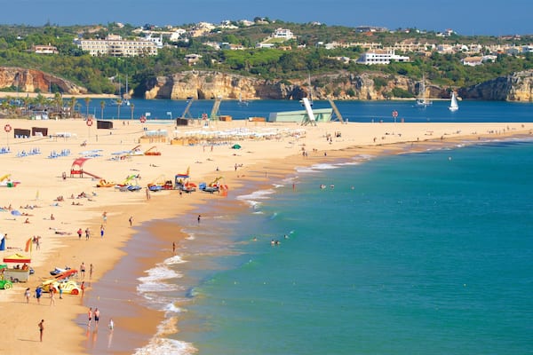 Ein überfüllter Strand mit Menschen, Sonnenschirmen und Booten.