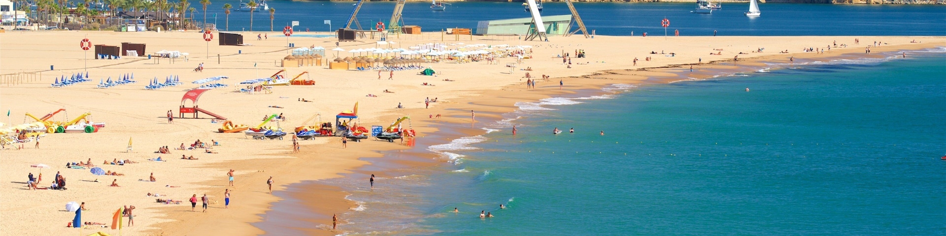 Rocha Beach showing a beach and general coastal views as well as a large group of people