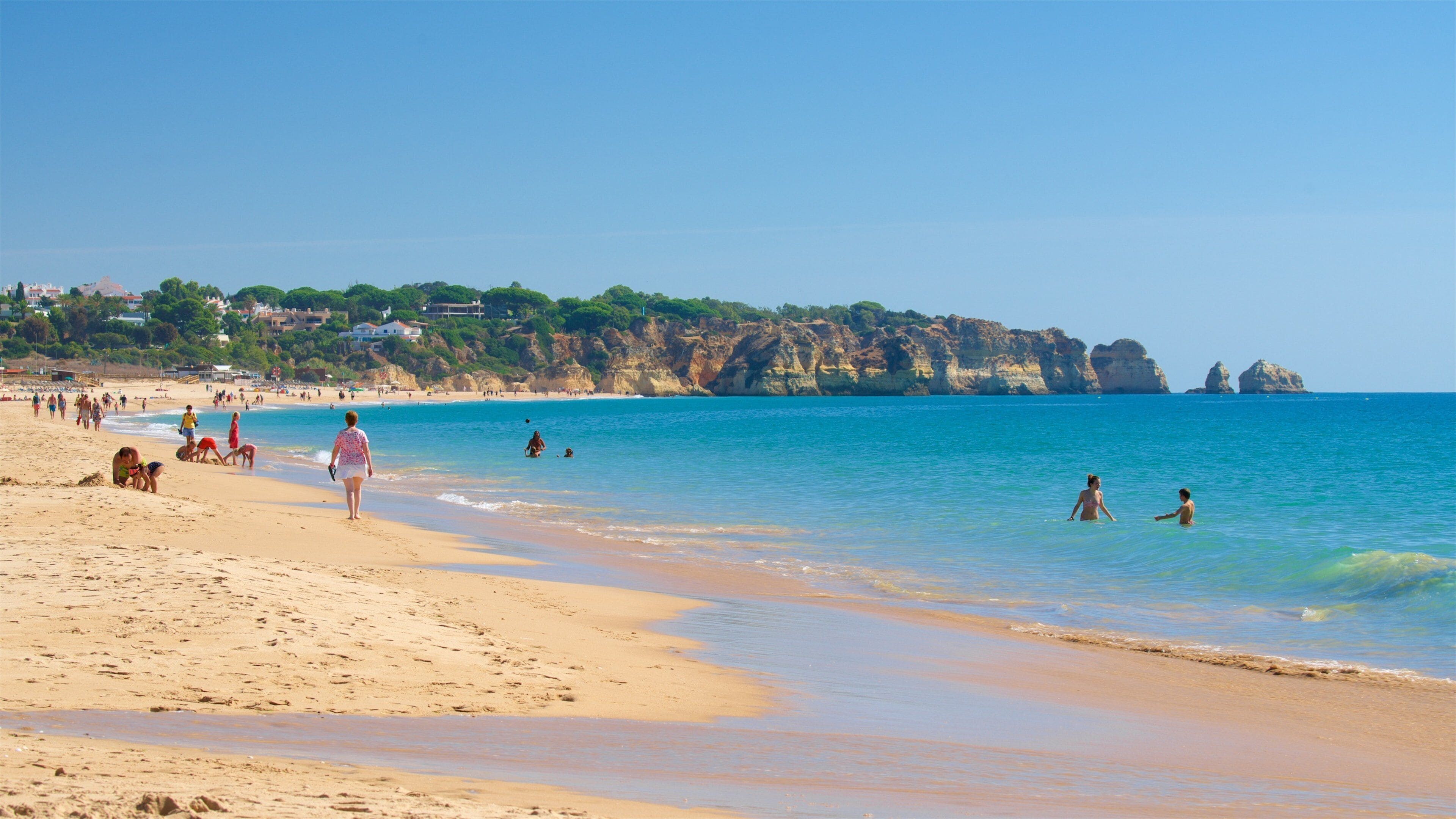 Alvor Beach which includes general coastal views, swimming and rocky coastline