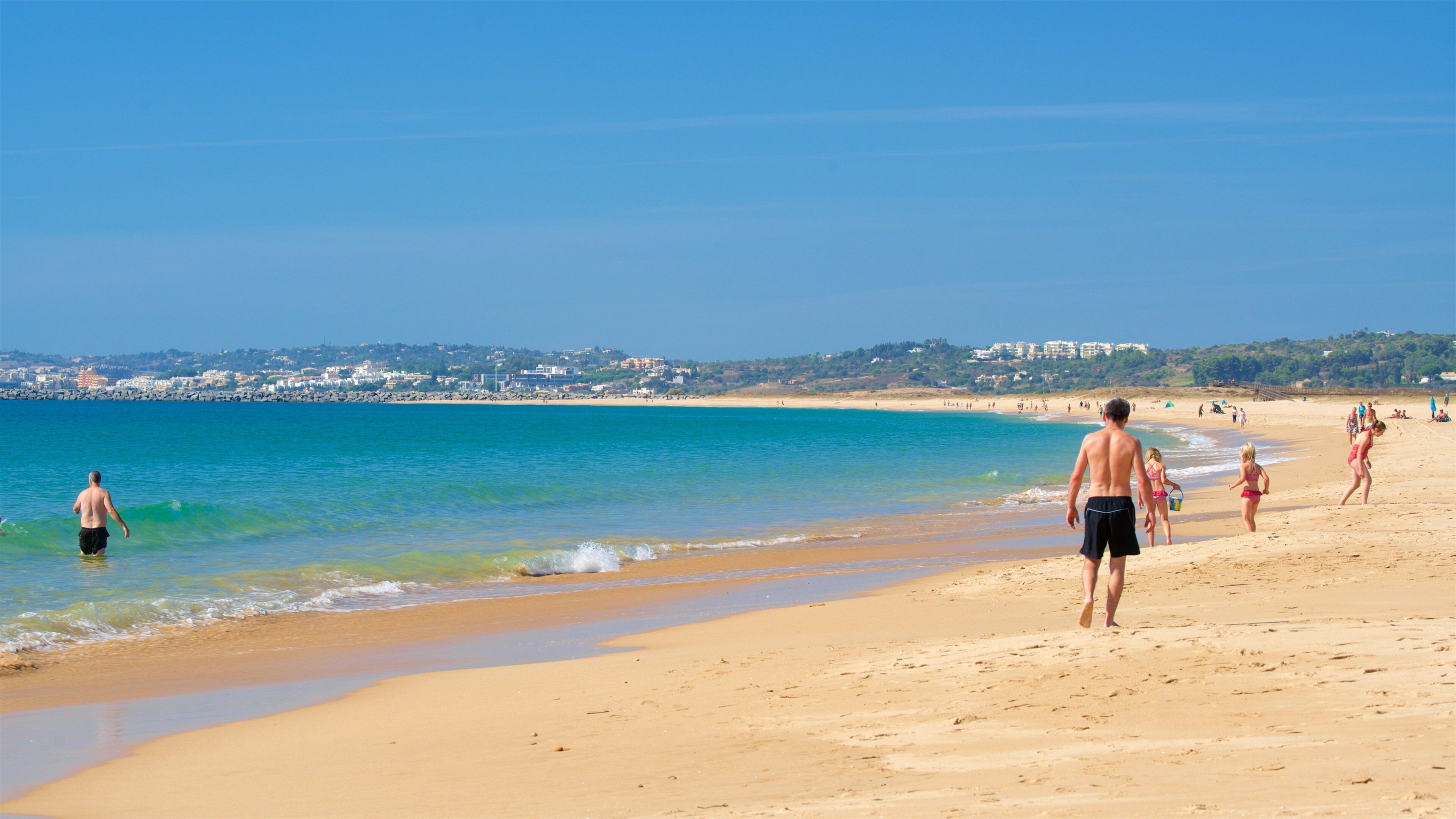 Alvor Beach showing general coastal views and a beach as well as a small group of people