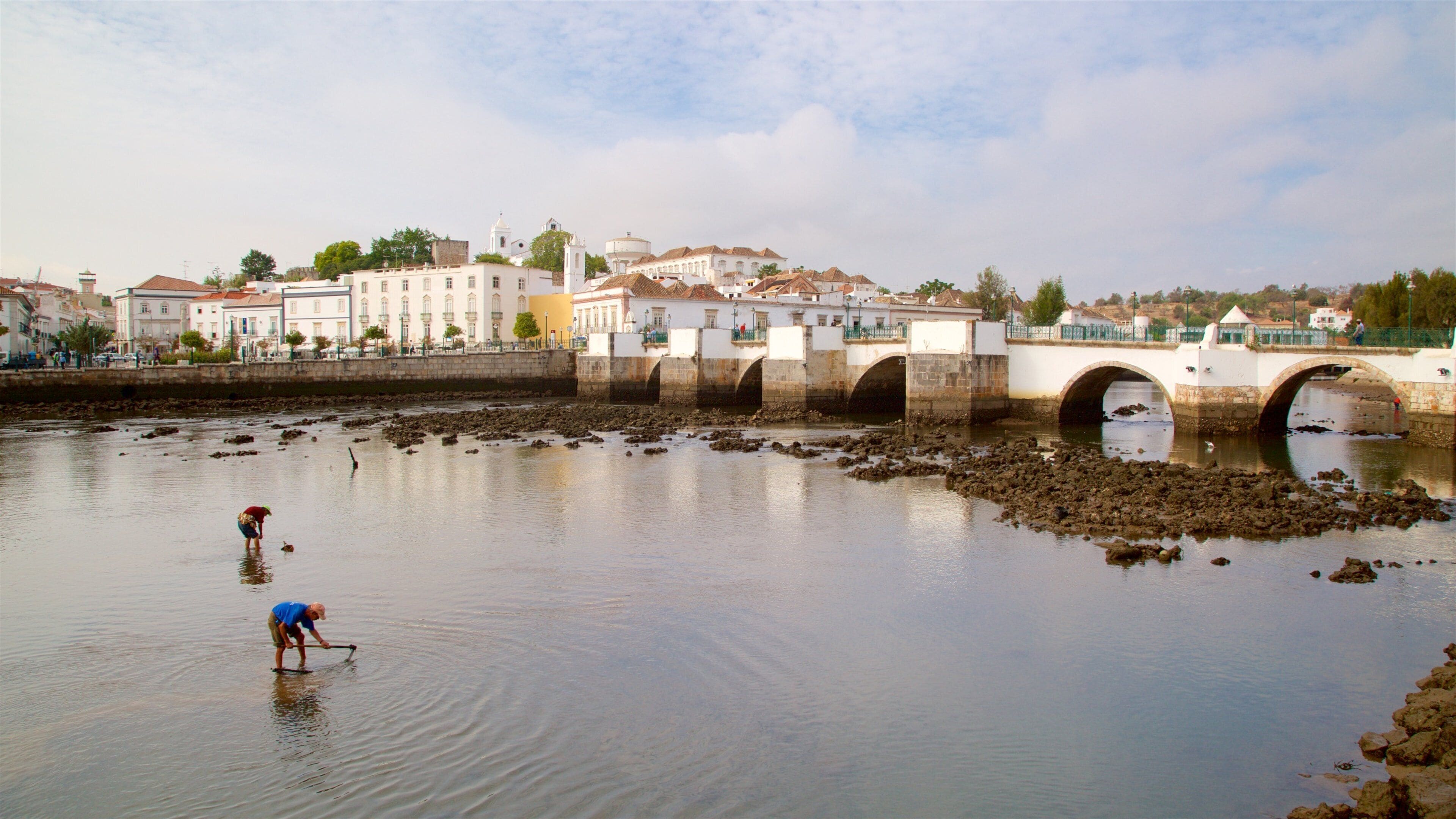 Puente romano mostrando un río o arroyo y un puente y también un pequeño grupo de personas