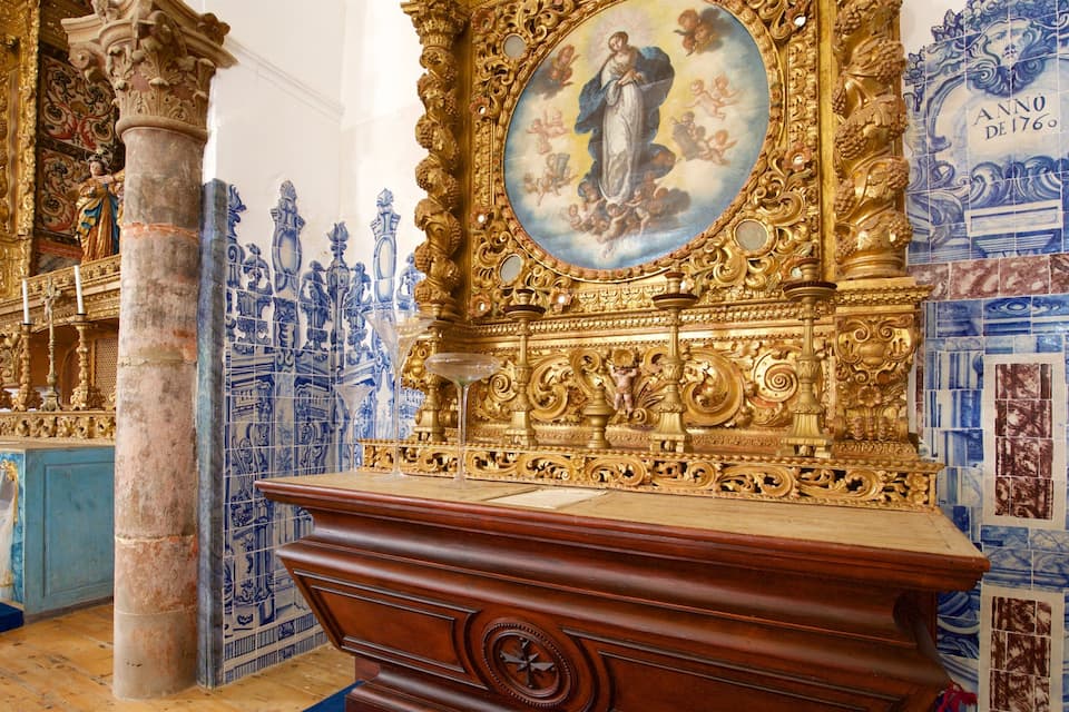 An ornate religious altar with a central painting, surrounded by blue and gold tiles.