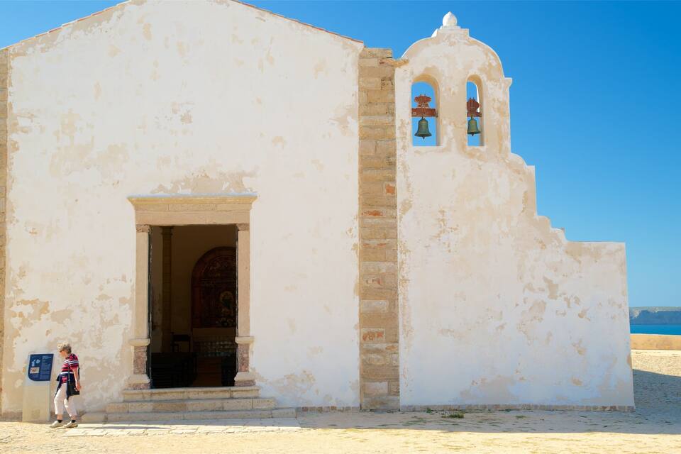 A white church with a bell tower and a clear blue sky.