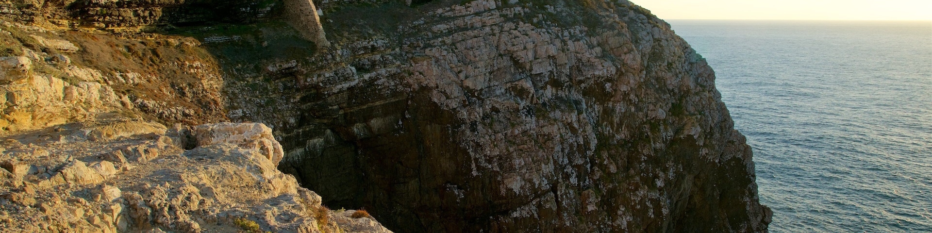 Cape St. Vincent Lighthouse which includes a lighthouse, general coastal views and rocky coastline