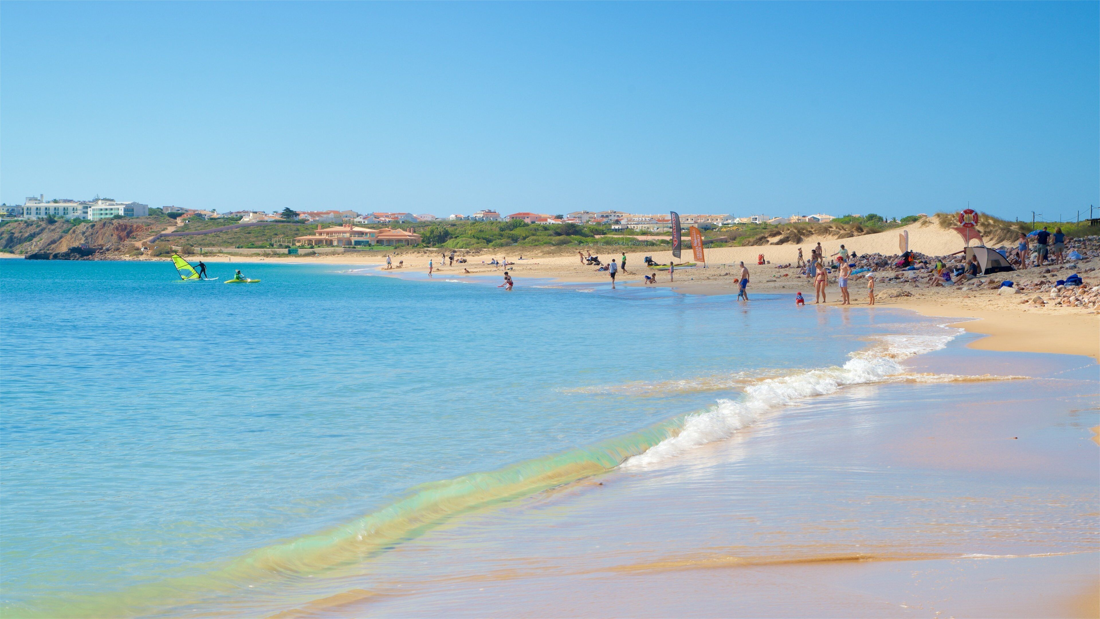 Martinhal Beach showing general coastal views and a beach as well as a small group of people