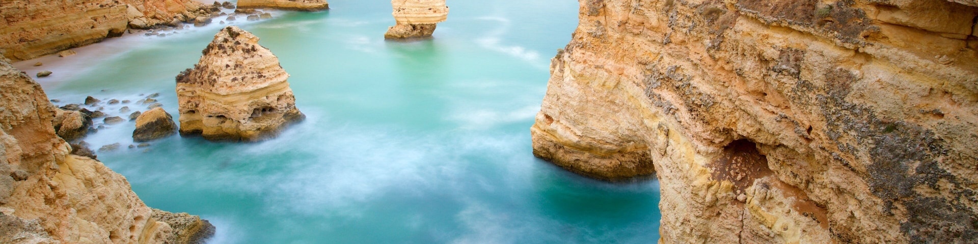 Playa Marinha que incluye litoral accidentado y vistas de una costa