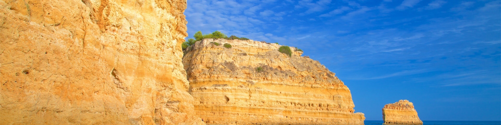 Playa Marinha que incluye costa rocosa, una playa de arena y surf