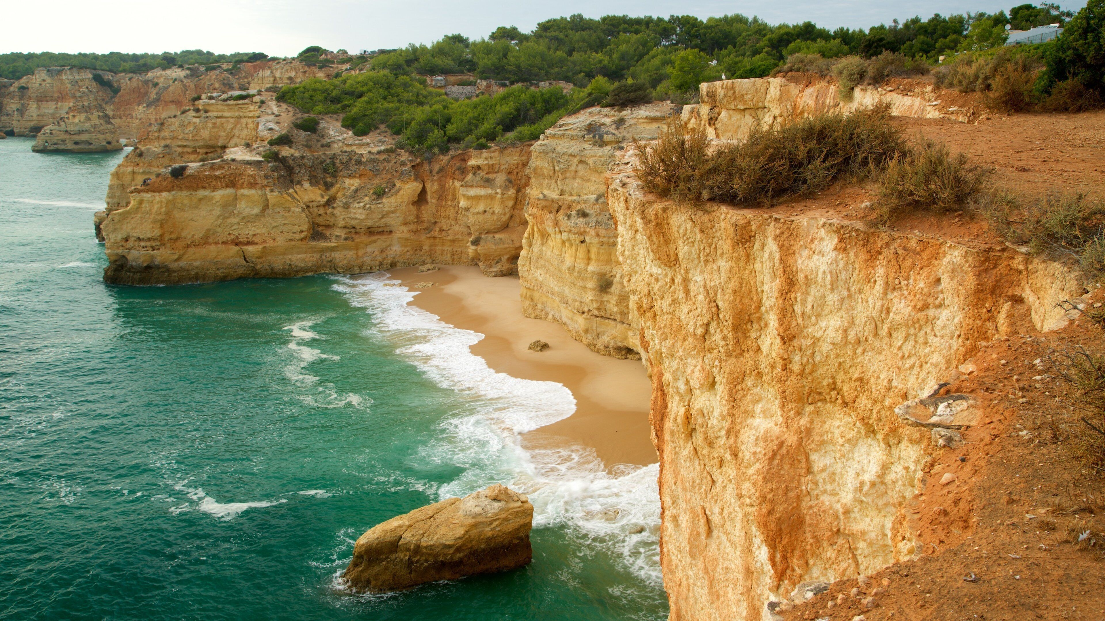 Playa Marinha mostrando costa escarpada, una playa de arena y vistas generales de la costa
