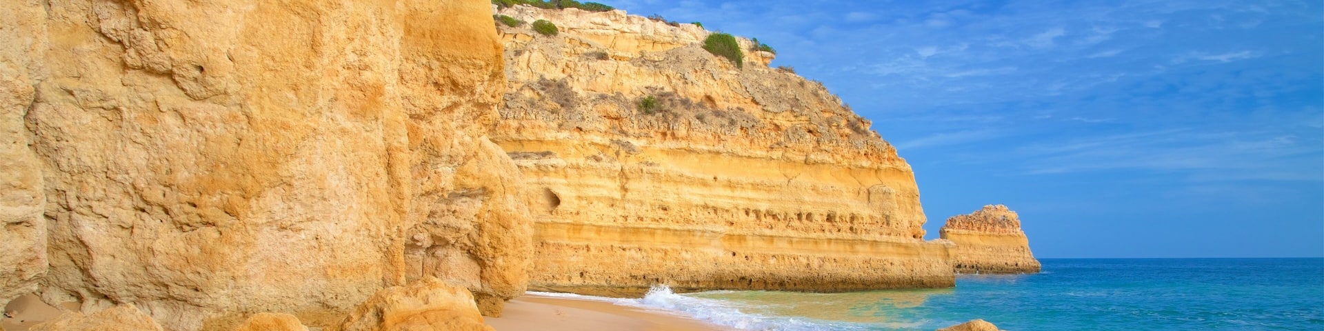 Marinha Beach showing rugged coastline, a sandy beach and general coastal views