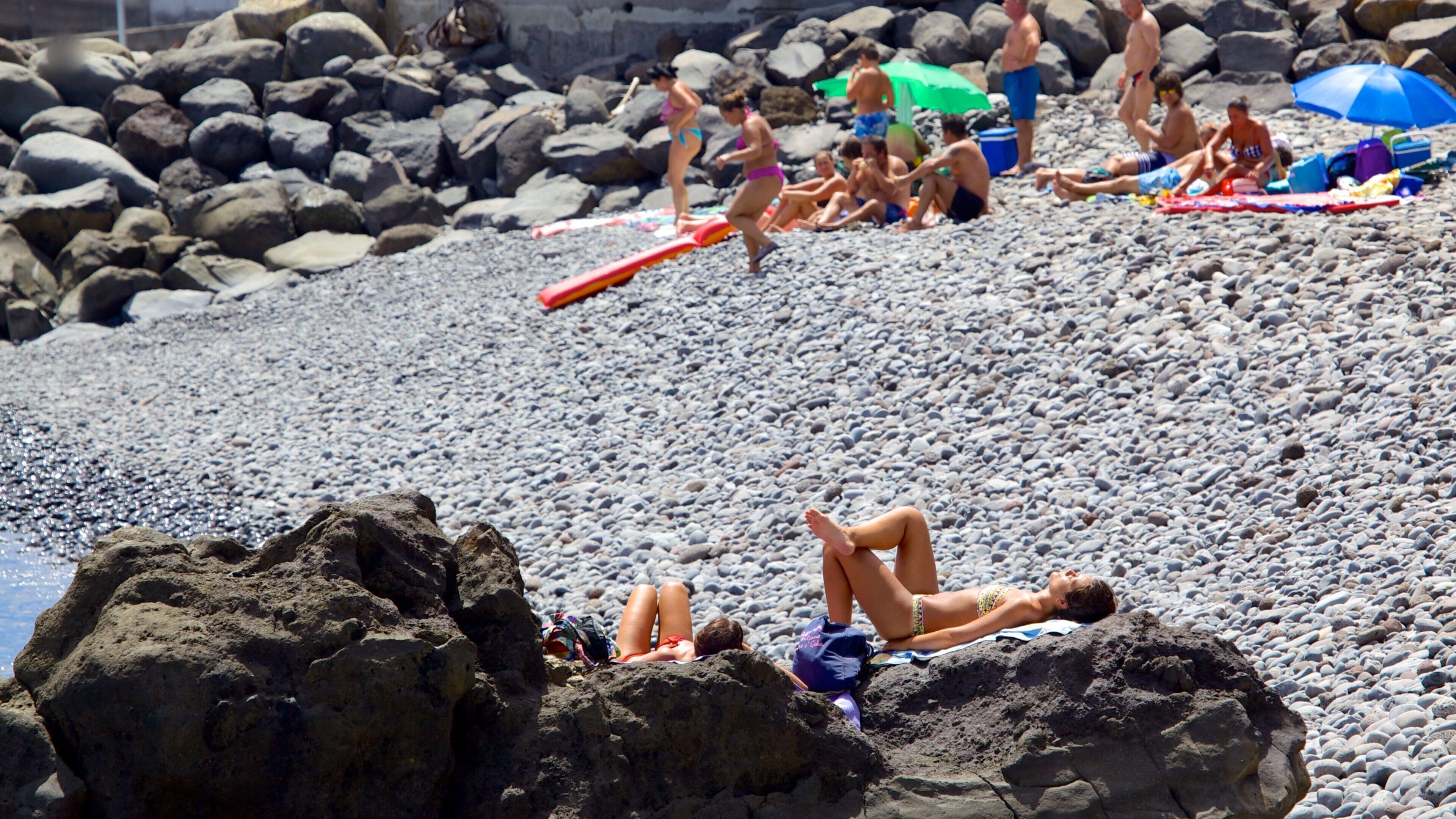 Playa de Santa Cruz ofreciendo una playa de guijarros y también un grupo grande de personas
