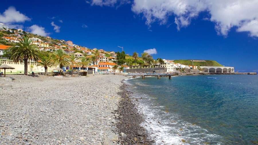 Playa de Santa Cruz mostrando una ciudad costera y una playa de piedras