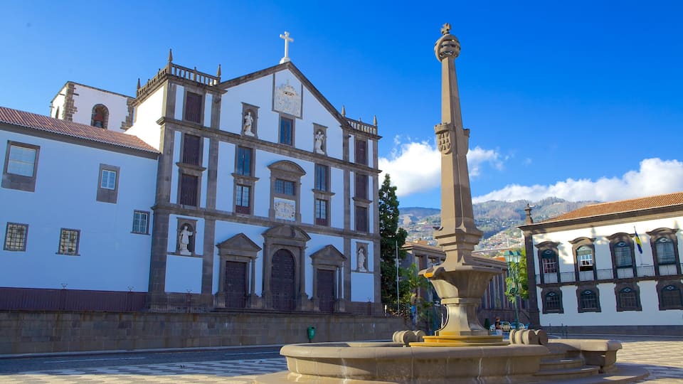 A historic building with a fountain in the foreground.