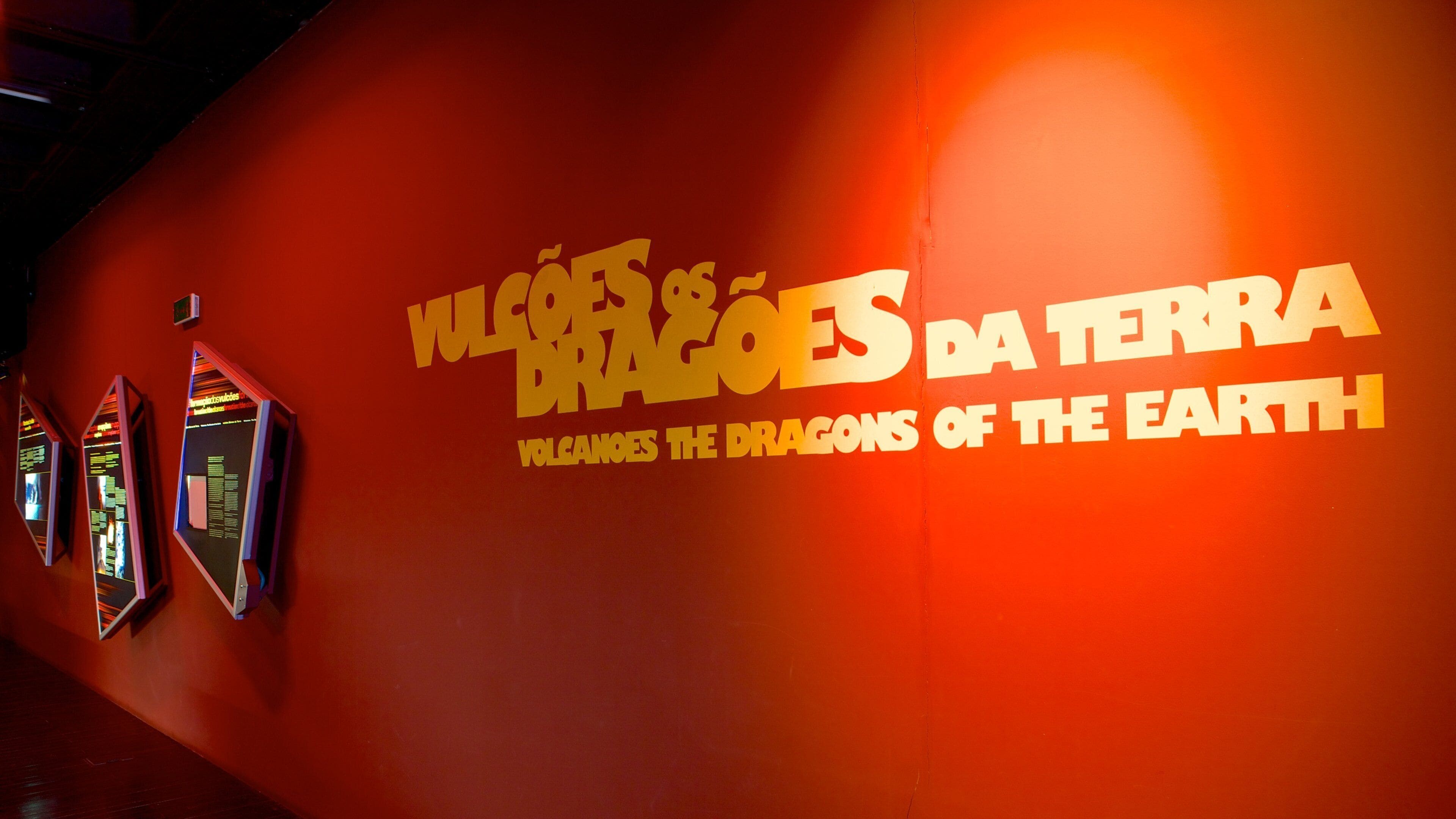 A red wall with the text "Wolves and Dragons da Terra" and "Wolves and Dragons of the Earth" in yellow.